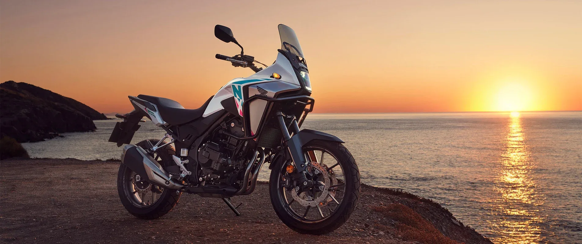 Honda NX500 E-Clutch beside the coast at sunset